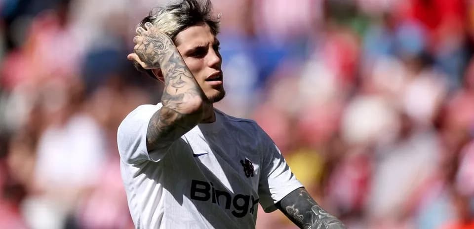 Player with tattoos in white jersey on field