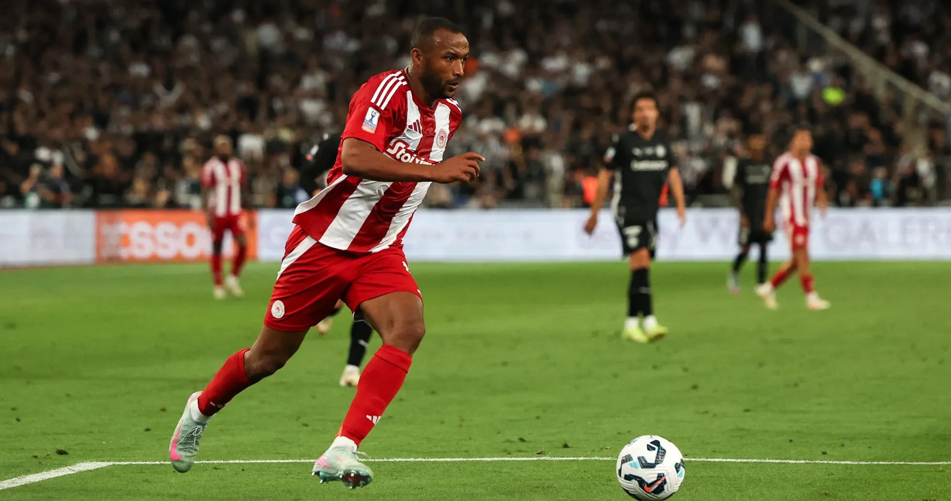 Player in red and white kit sprinting with ball