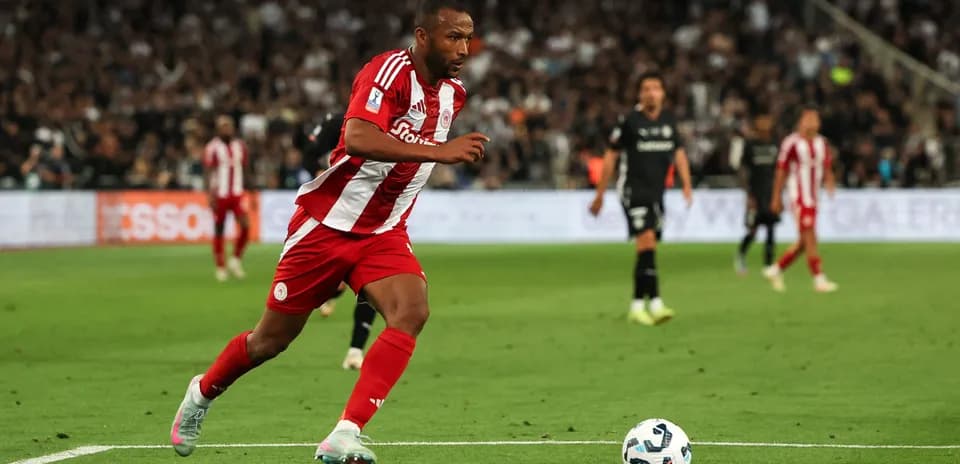 Player in red and white kit sprinting with ball