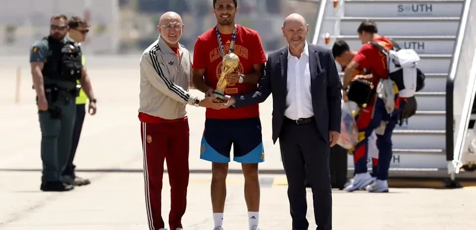 Player receiving trophy upon arrival at airport