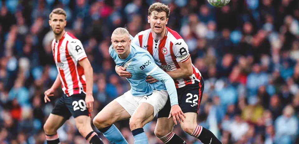 Erling Haaland challenged by Brentford defender