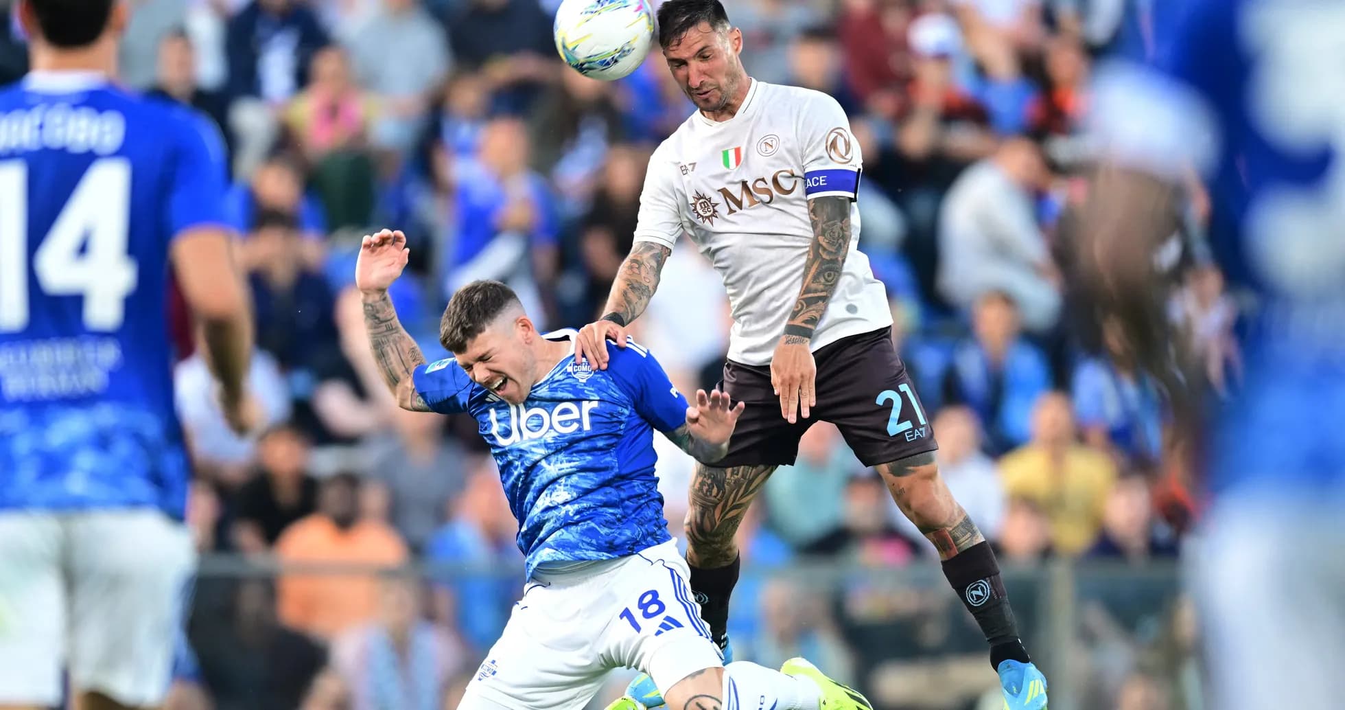 Napoli player challenges Como player during match Napoli player challenges Como player during match