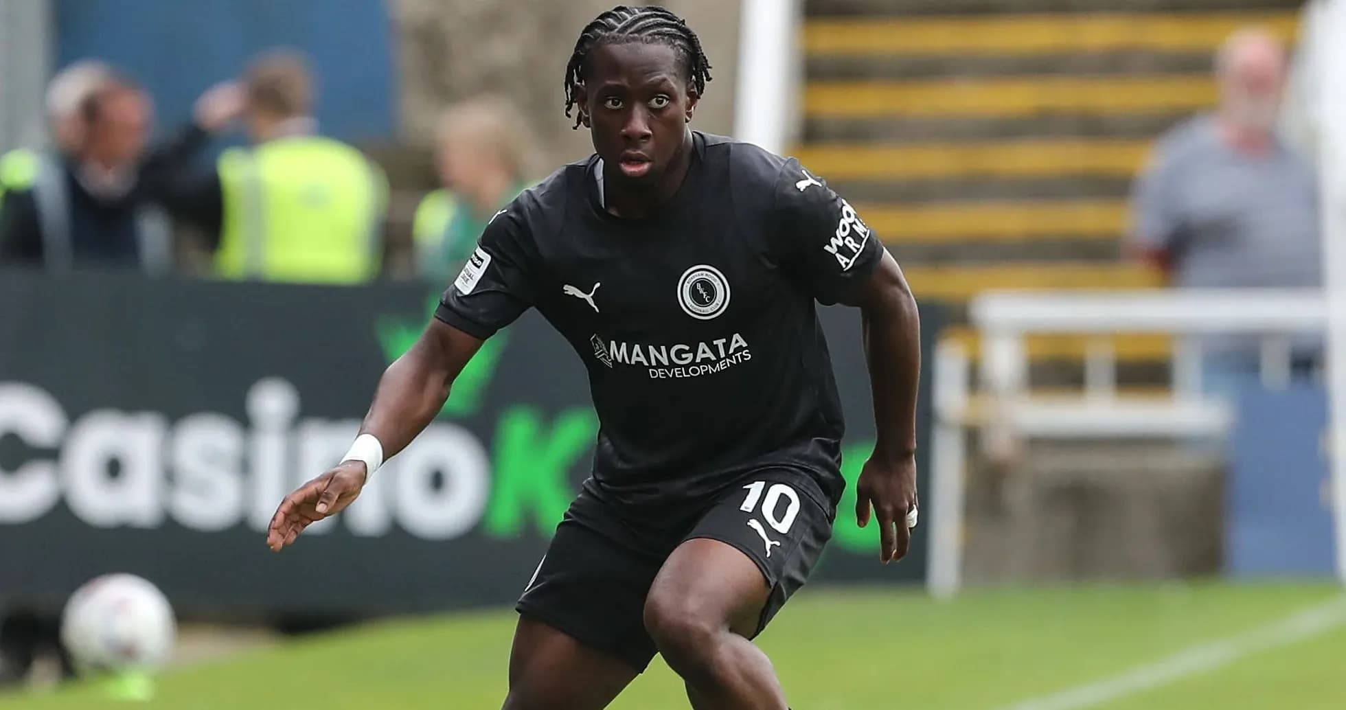 Player in black kit running on the field Player in black kit running on the field