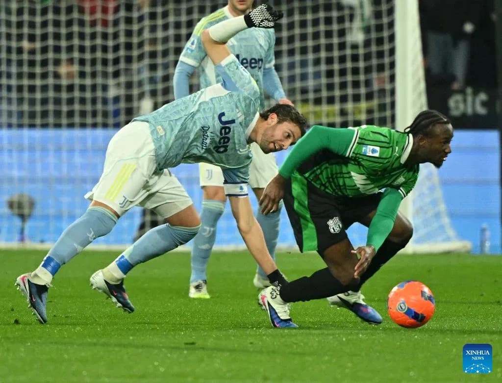 Juventus player tackling Sassuolo opponent during match Juventus player tackling Sassuolo opponent during match
