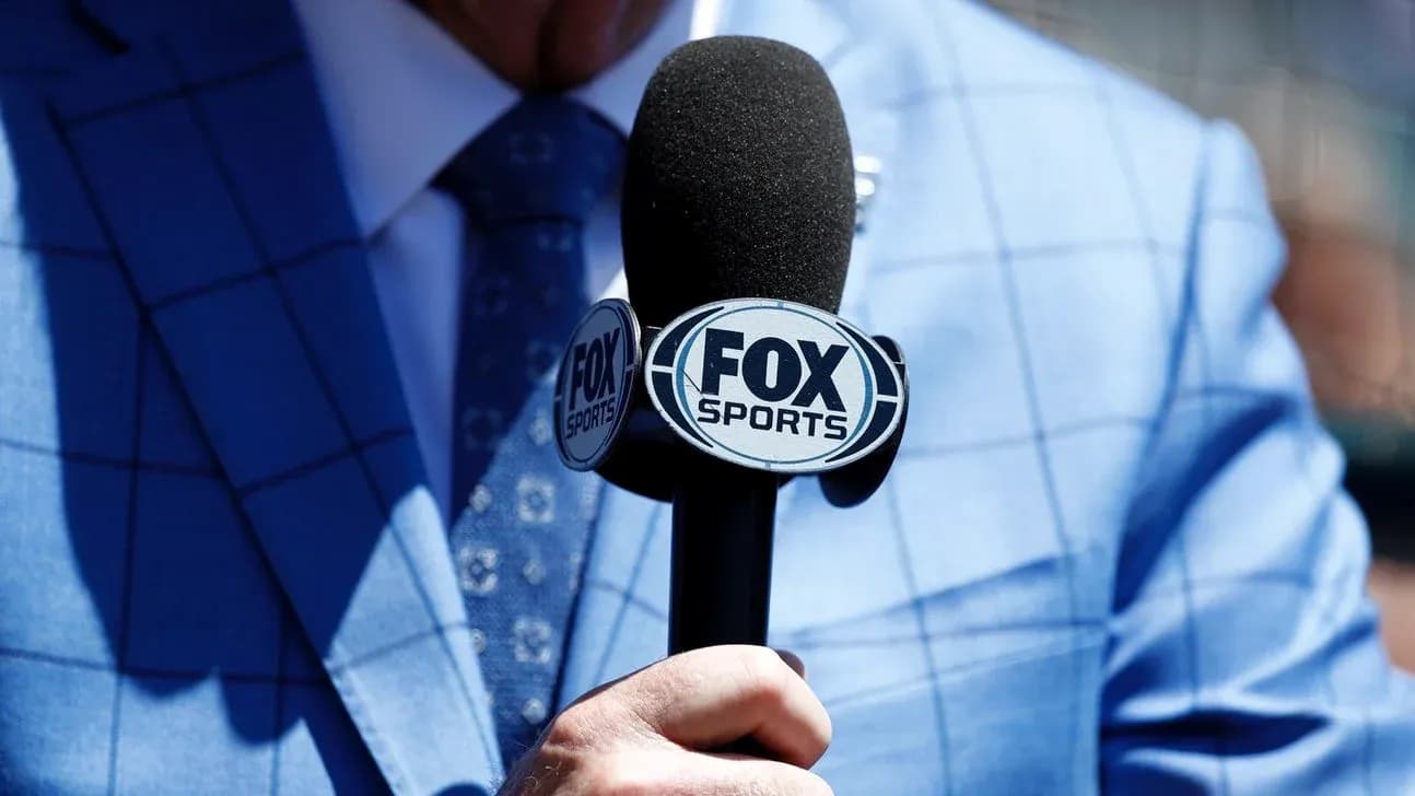 Microphone with FOX Sports logo held by a person Microphone with FOX Sports logo held by a person
