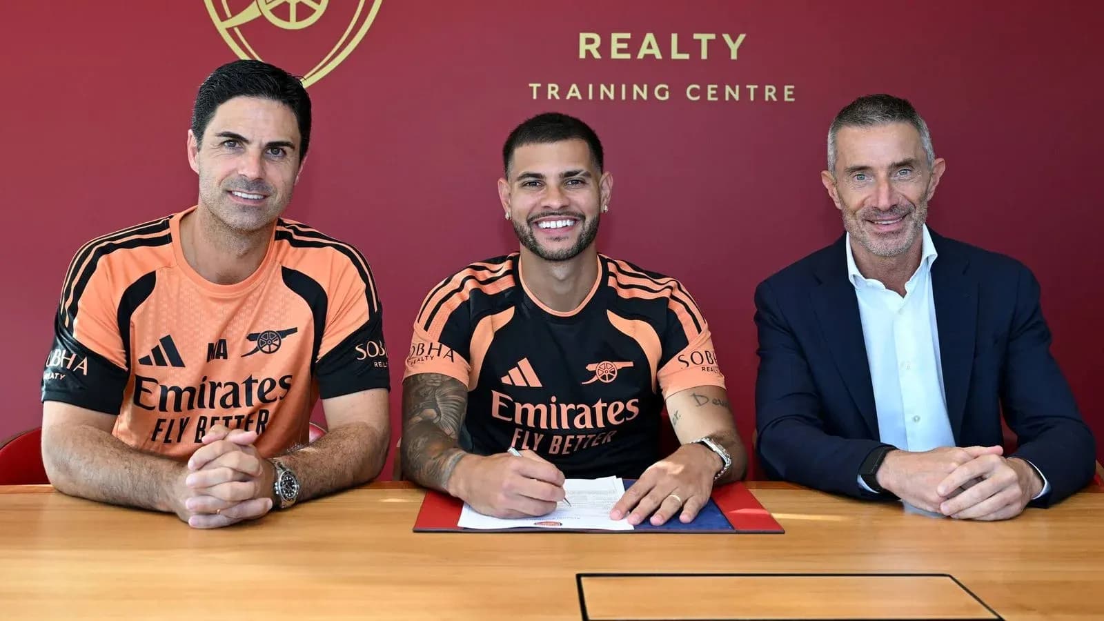 Player signing contract with club officials at table Player signing contract with club officials at table