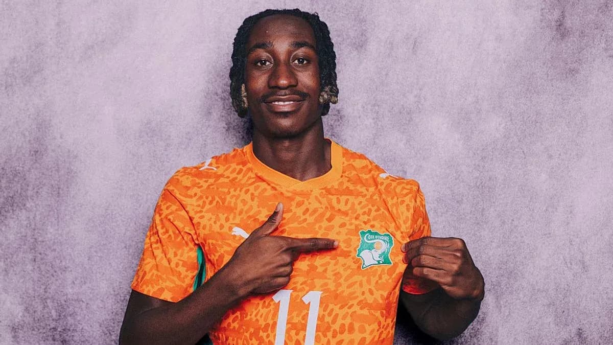 Player in orange jersey pointing at Ivorian crest Player in orange jersey pointing at Ivorian crest
