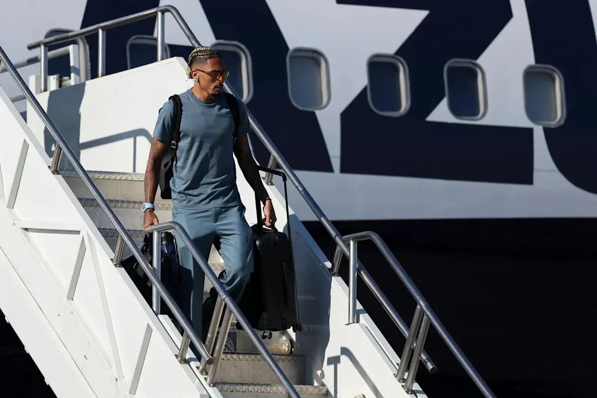 Player exiting airplane with luggage at airport Player exiting airplane with luggage at airport