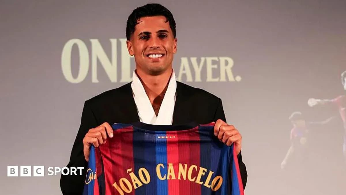 João Cancelo holding FC Barcelona jersey at presentation João Cancelo holding FC Barcelona jersey at presentation