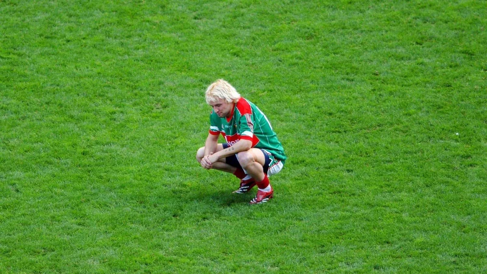 Player squatting on the field during match Player squatting on the field during match