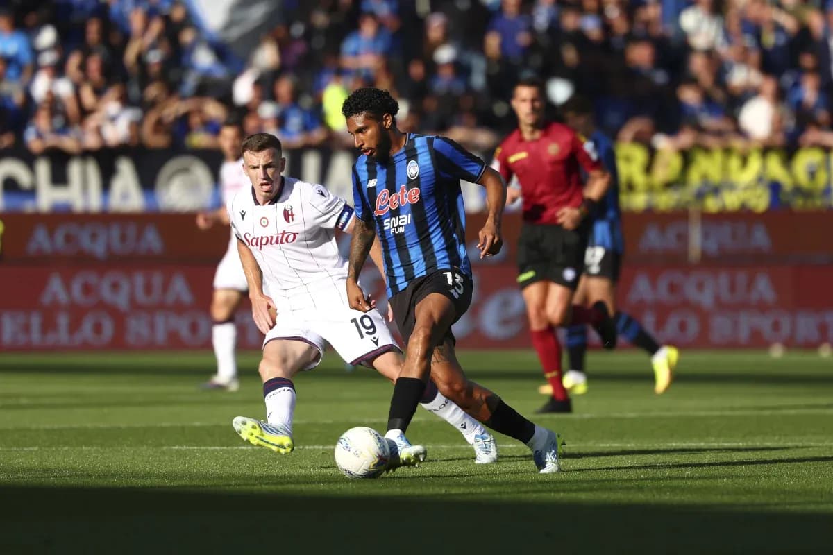 Atalanta player dribbling against Bologna defender Atalanta player dribbling against Bologna defender