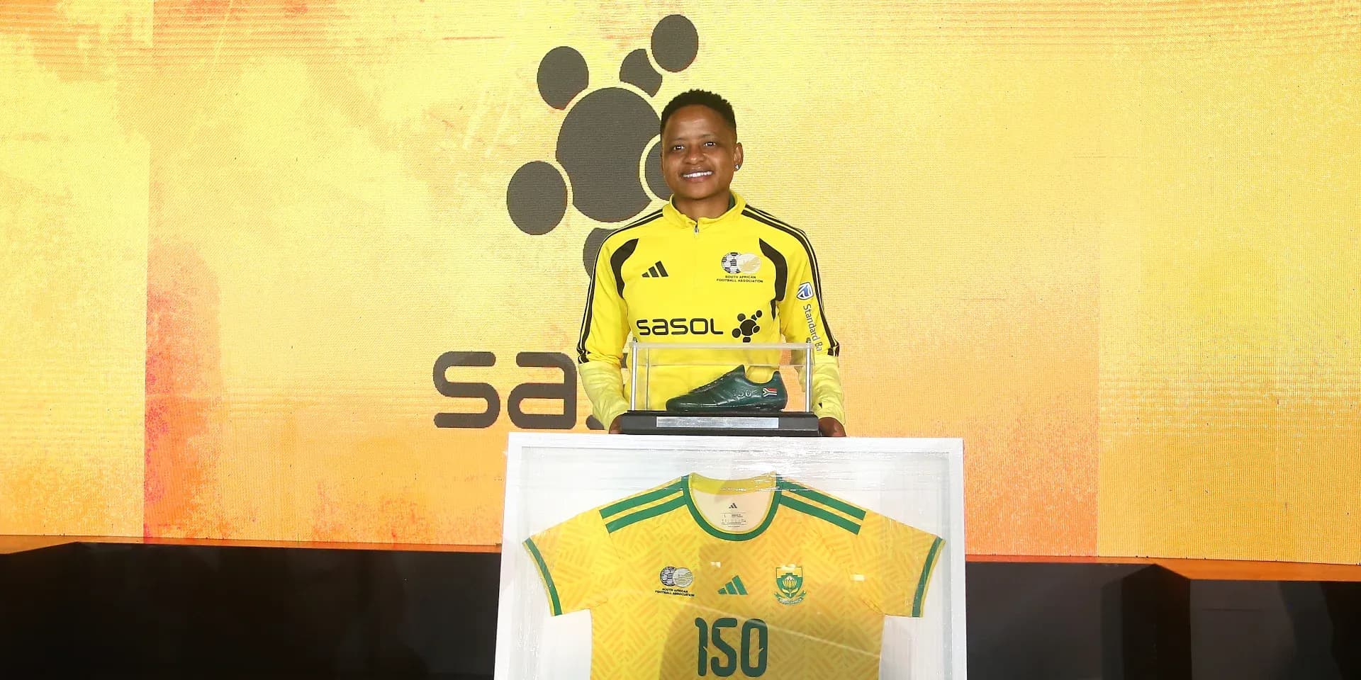 Player holding a shoe and jersey at event Player holding a shoe and jersey at event