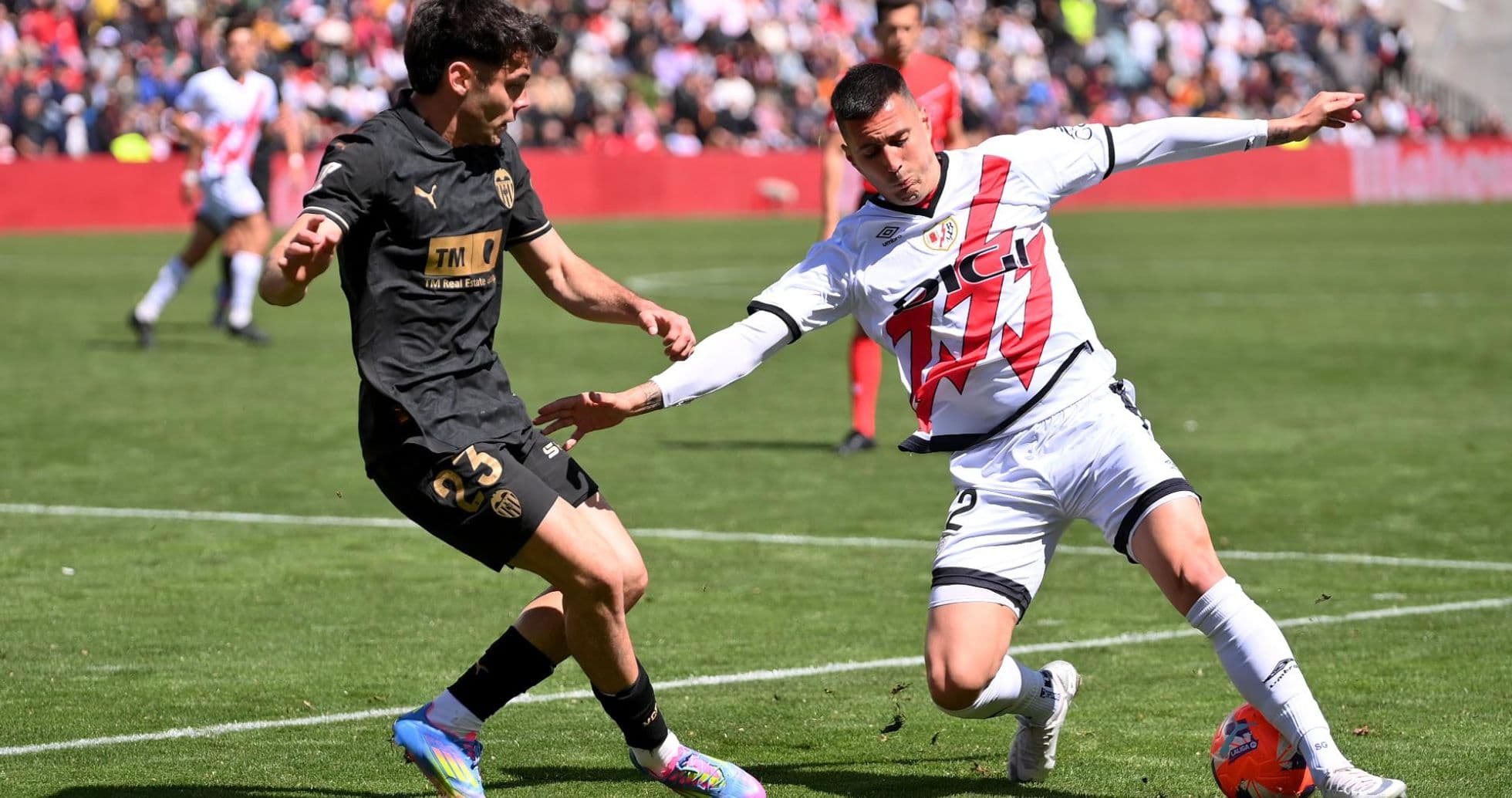 Valencia player tackling Rayo Vallecano opponent Valencia player tackling Rayo Vallecano opponent