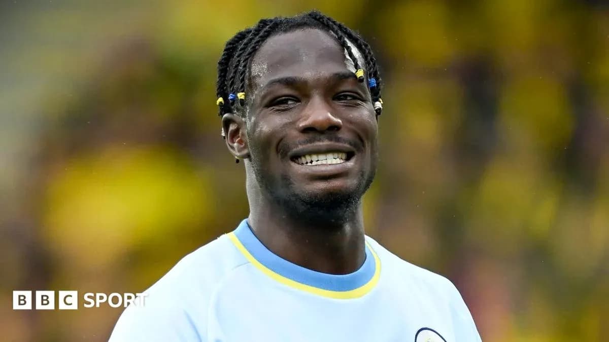Player smiling while wearing team jersey on field Player smiling while wearing team jersey on field