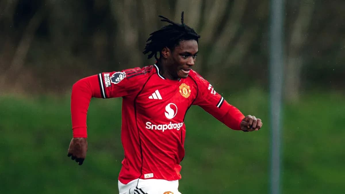 Player in red Manchester United jersey running on field Player in red Manchester United jersey running on field