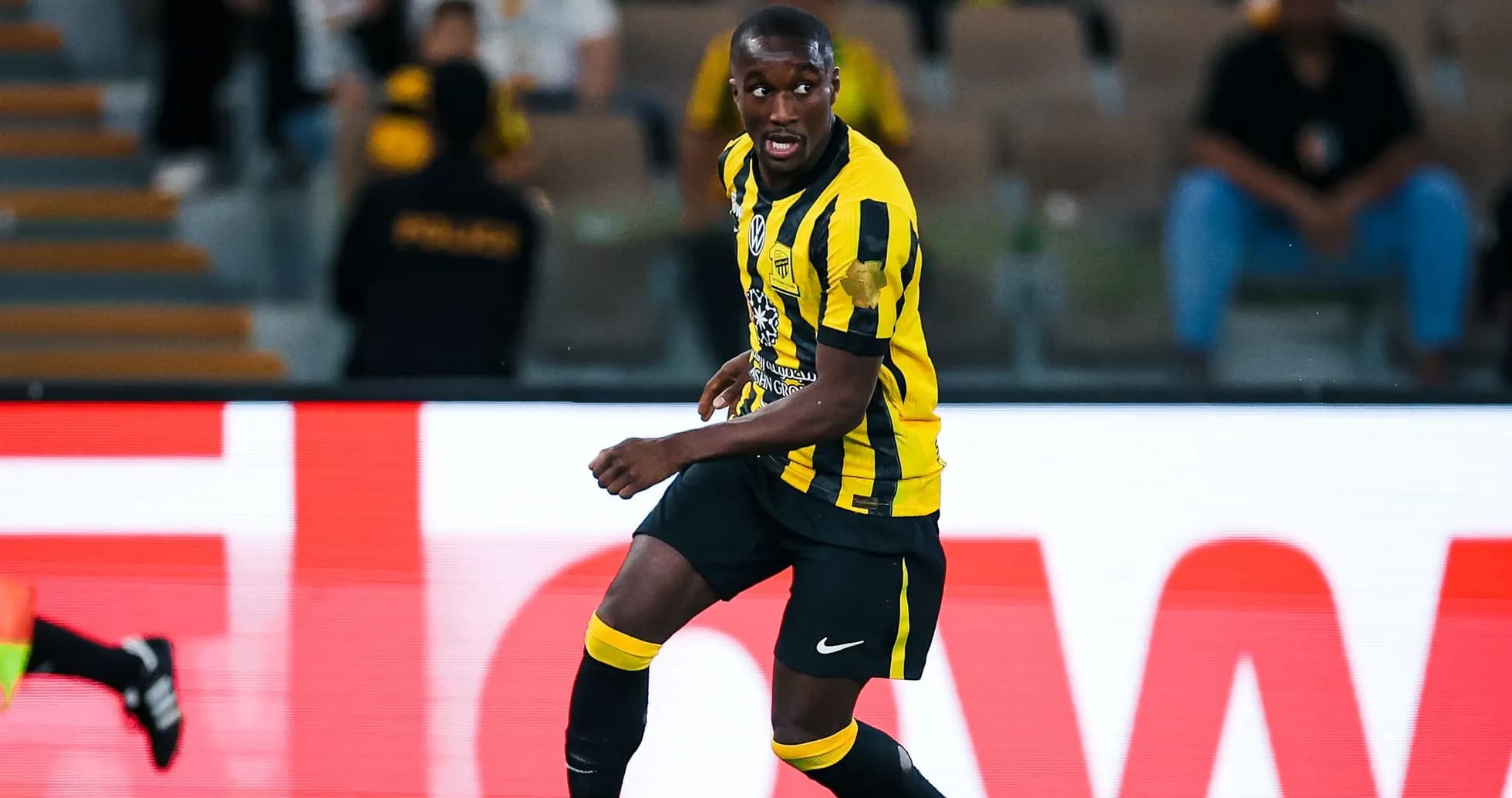 Player in yellow and black kit during match Player in yellow and black kit during match