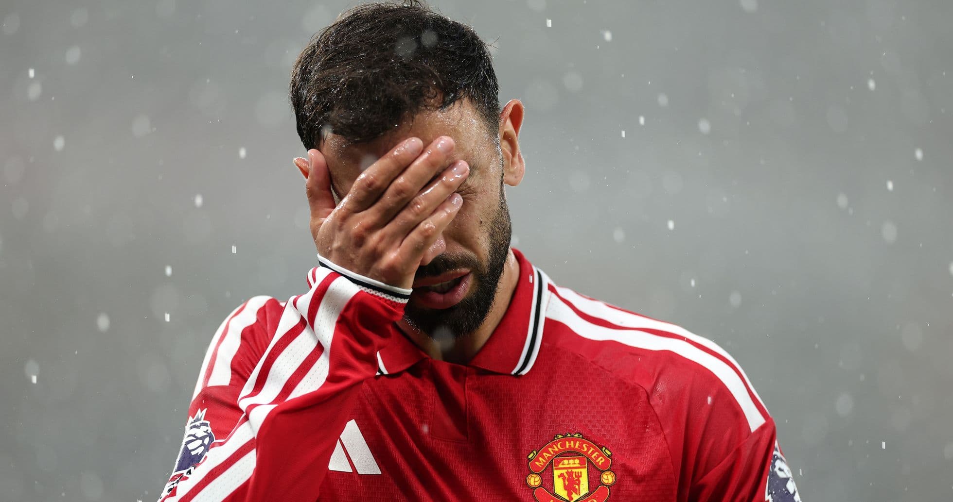 Player covering face in rain during match Player covering face in rain during match
