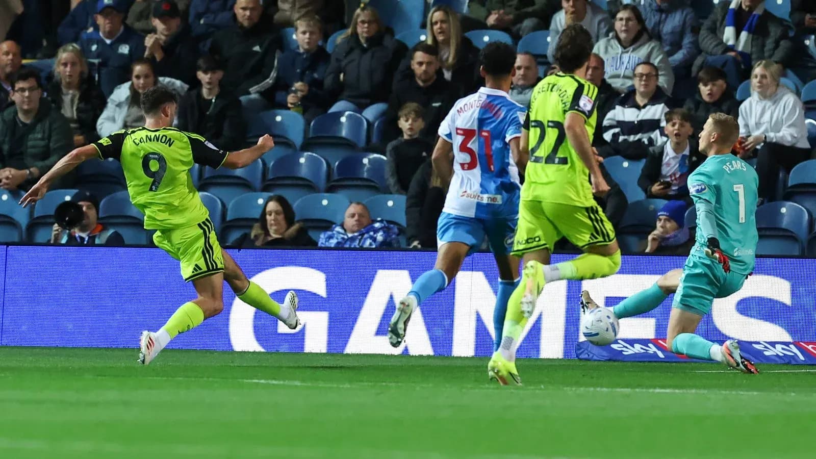 Player shooting on goal while goalkeeper attempts save Player shooting on goal while goalkeeper attempts save