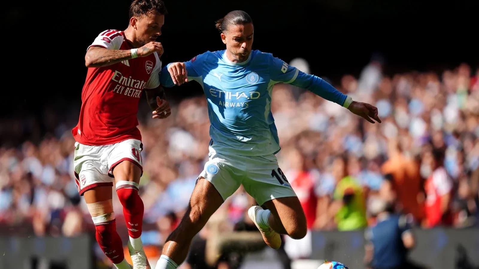 Arsenal and Manchester City players competing for the ball Arsenal and Manchester City players competing for the ball
