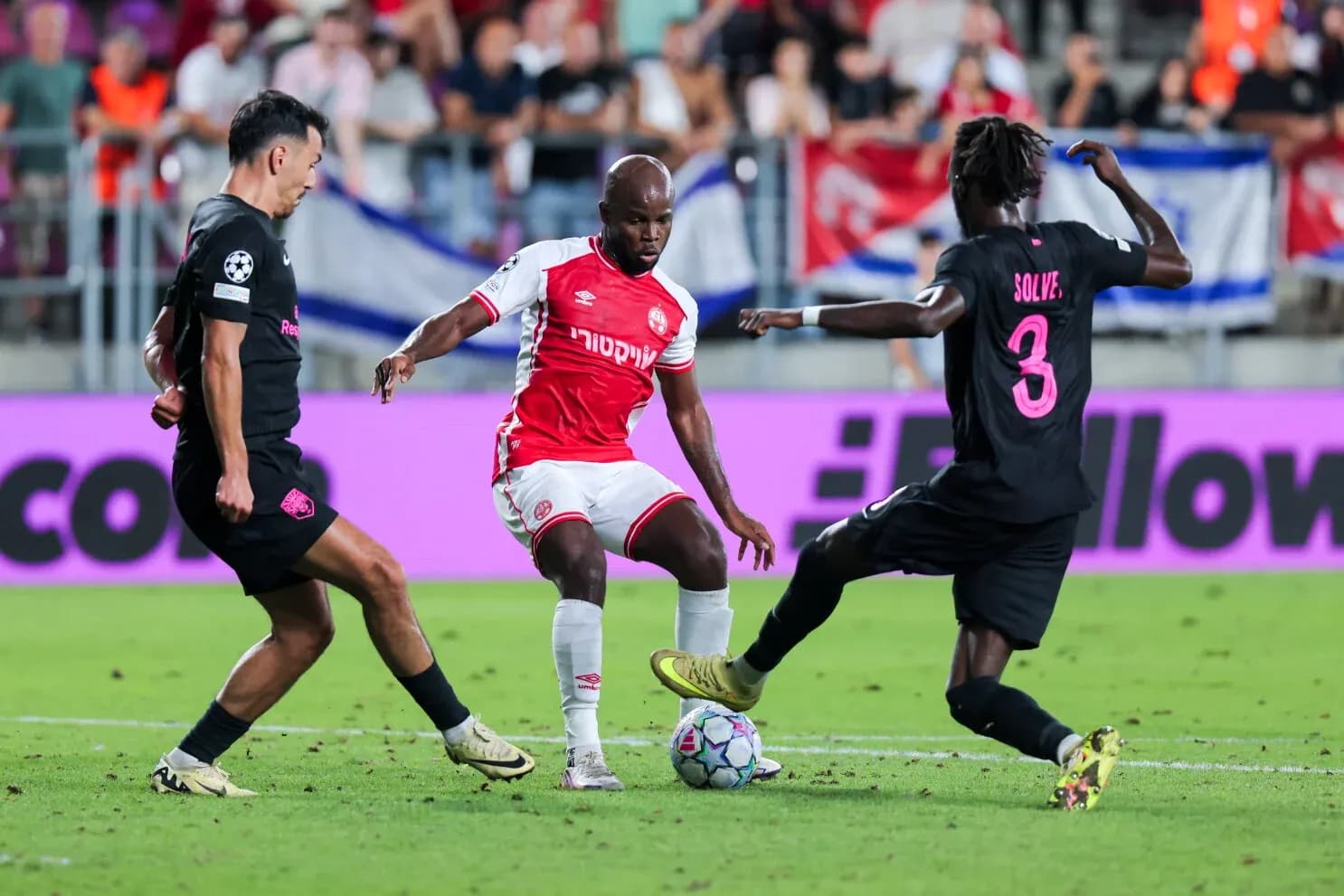 Players competing for the ball in UEFA match Players competing for the ball in UEFA match