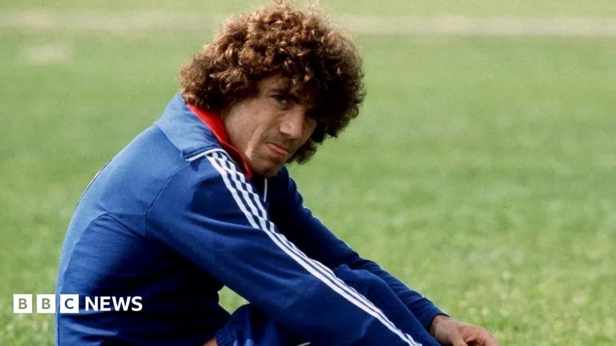 Player sitting on grass field in training attire Player sitting on grass field in training attire