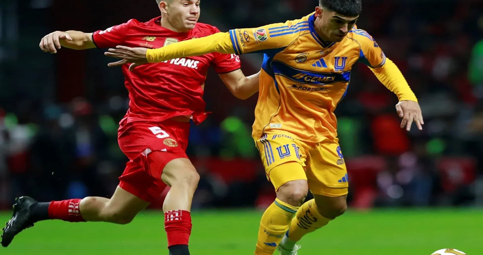 Toluca player challenging Tigres UANL player for ball Toluca player challenging Tigres UANL player for ball