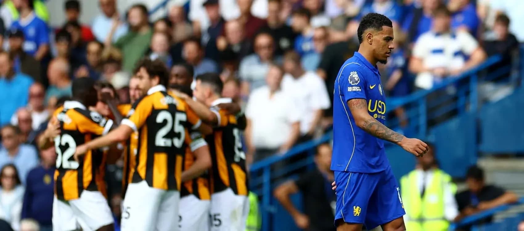 Player walking past celebrating teammates after goal Player walking past celebrating teammates after goal