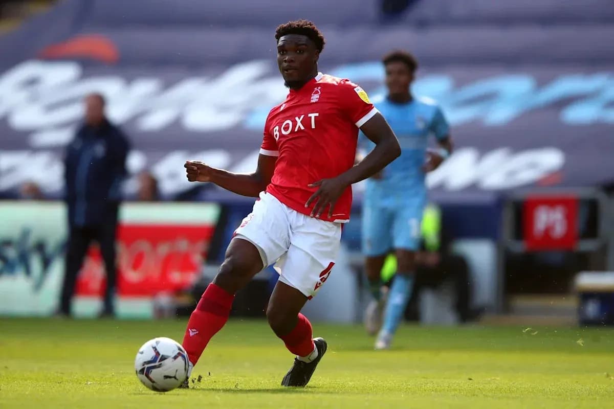 Player in red kit dribbling the ball on field Player in red kit dribbling the ball on field
