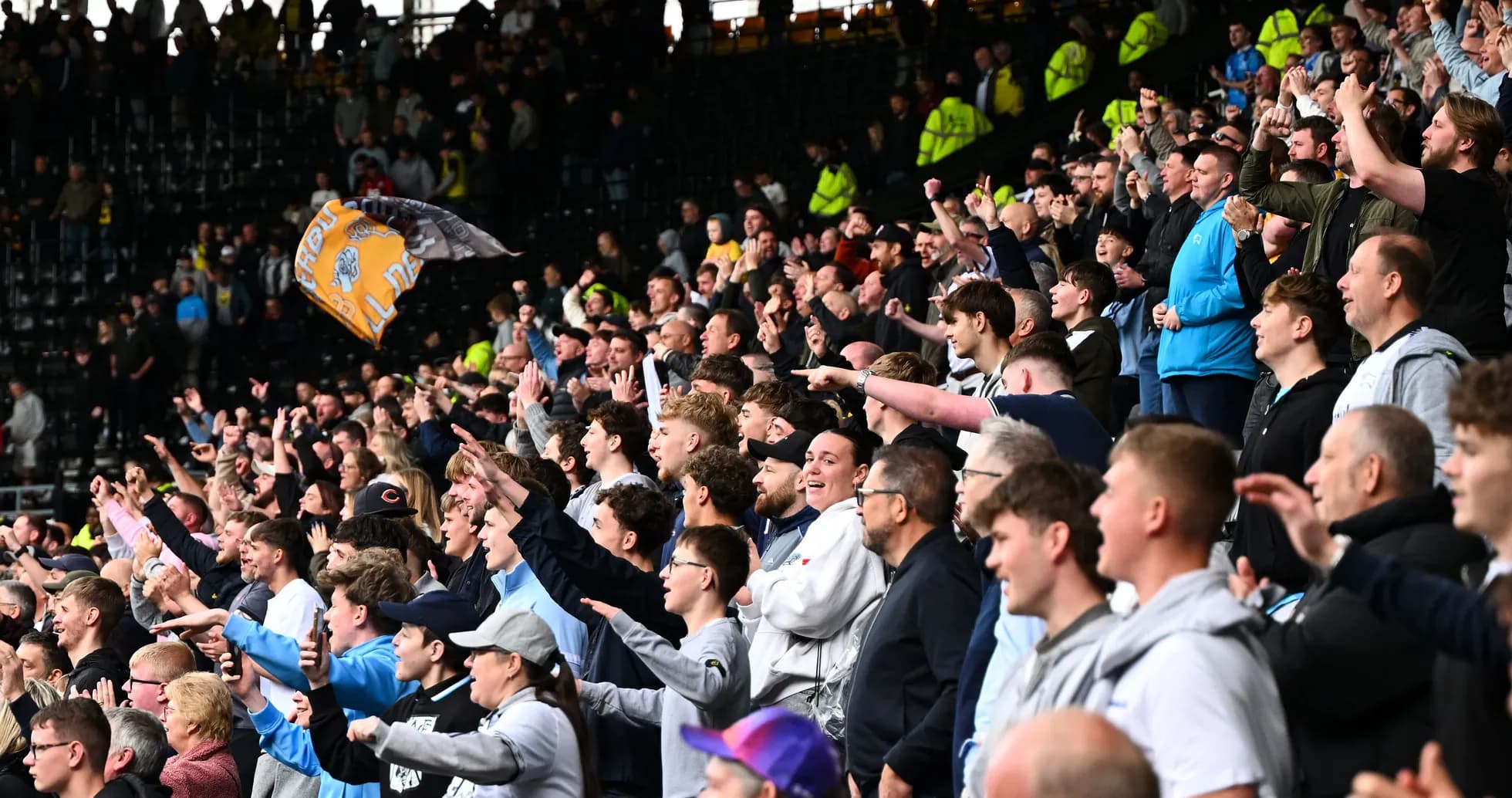 Fans cheering enthusiastically in stadium stands Fans cheering enthusiastically in stadium stands