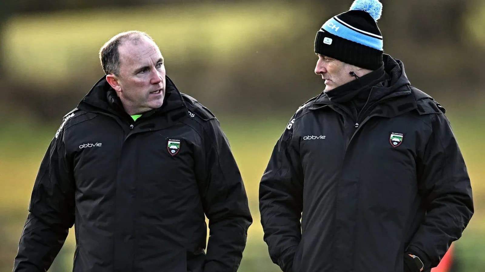 Two coaches talking on a training field Two coaches talking on a training field