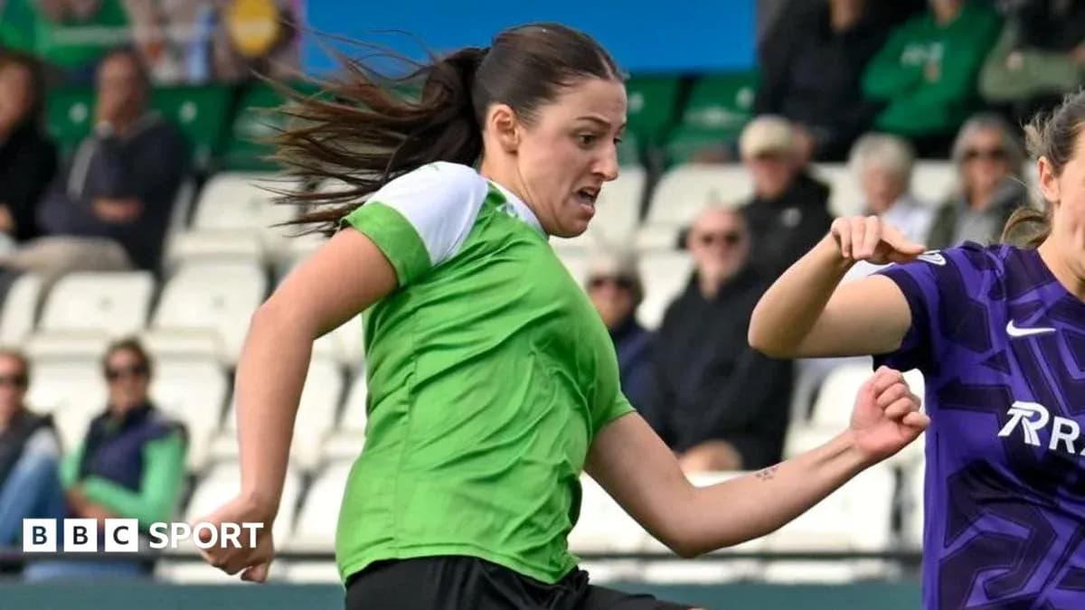 Player in green jersey dribbling past opponent Player in green jersey dribbling past opponent