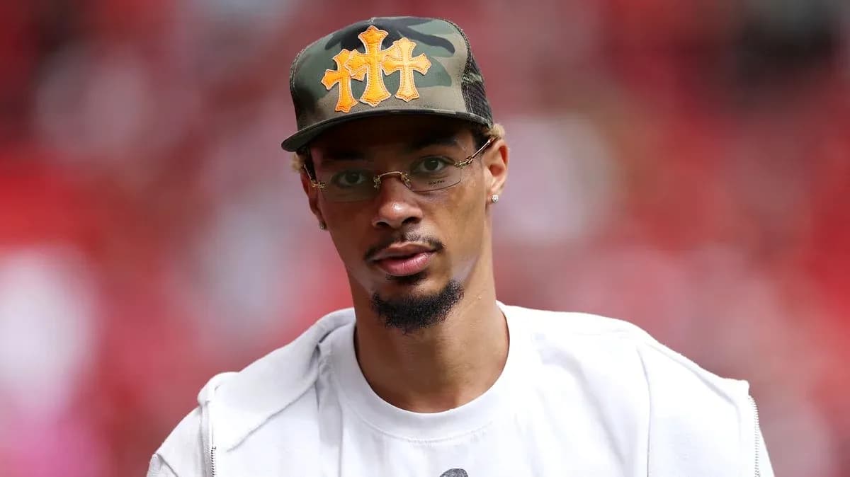 Person wearing a cap and glasses at event Person wearing a cap and glasses at event