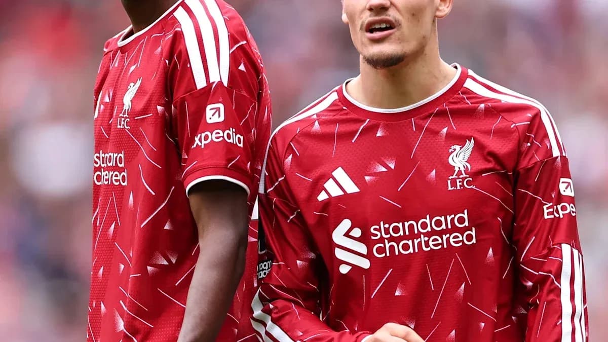Two Liverpool players in red jerseys on field Two Liverpool players in red jerseys on field