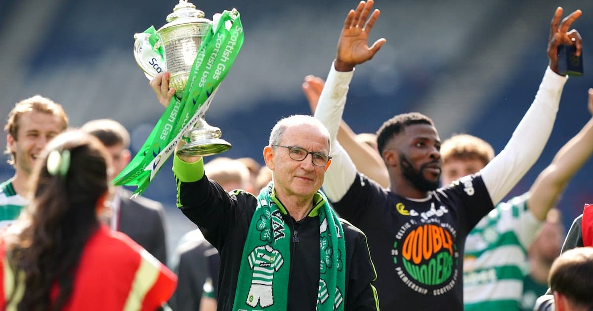 Man holding trophy with team celebrating in background Man holding trophy with team celebrating in background