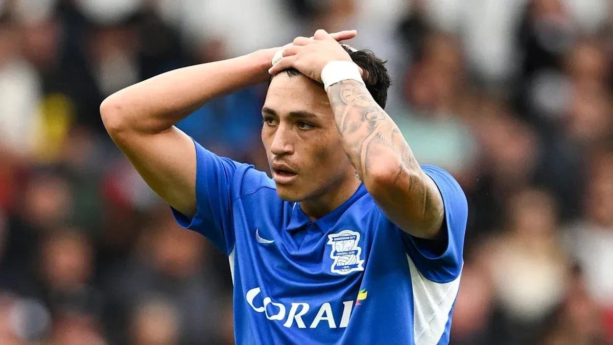 Player in blue jersey holding head in distress Player in blue jersey holding head in distress