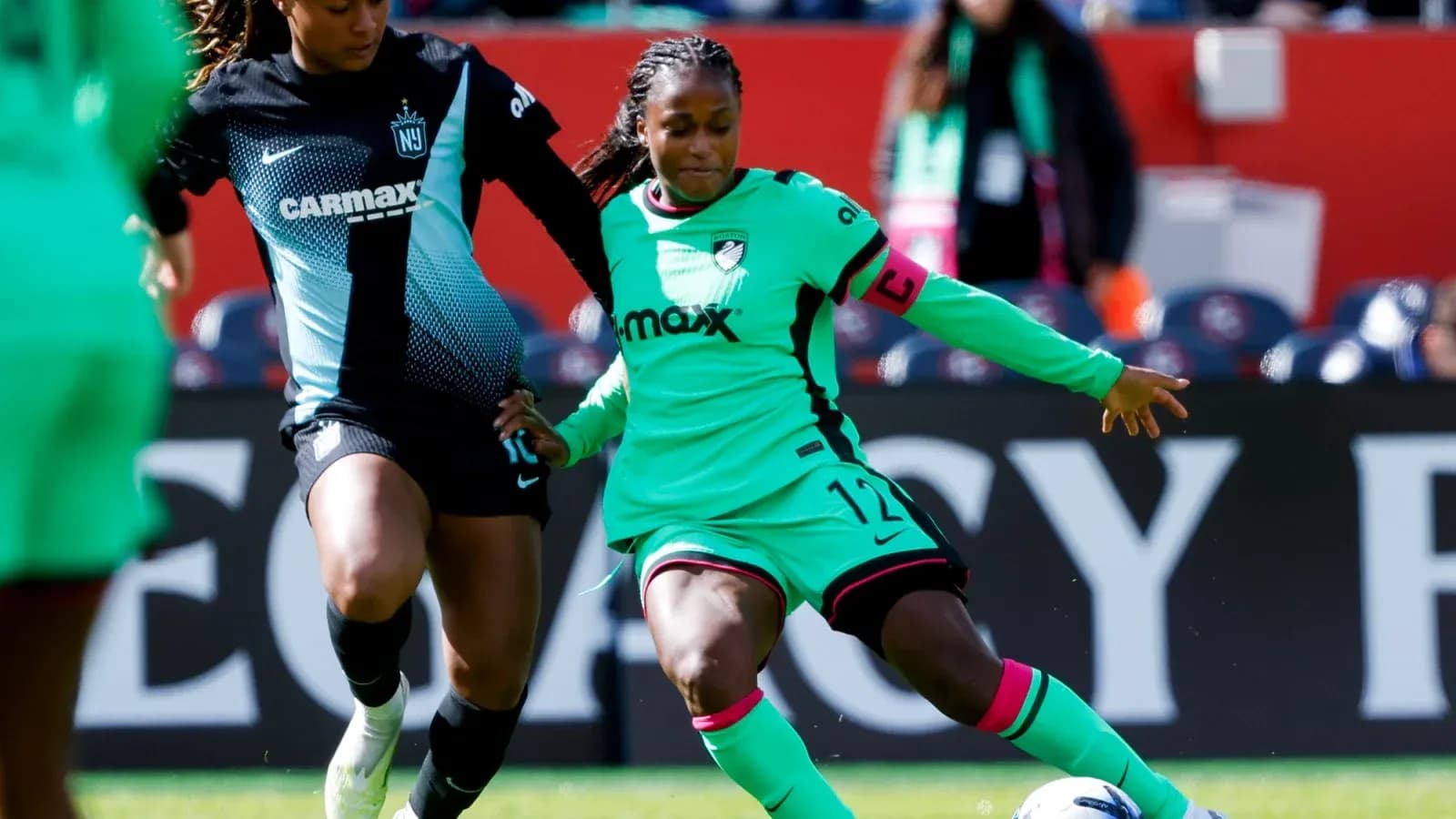 Two players competing for the ball in NWSL match Two players competing for the ball in NWSL match
