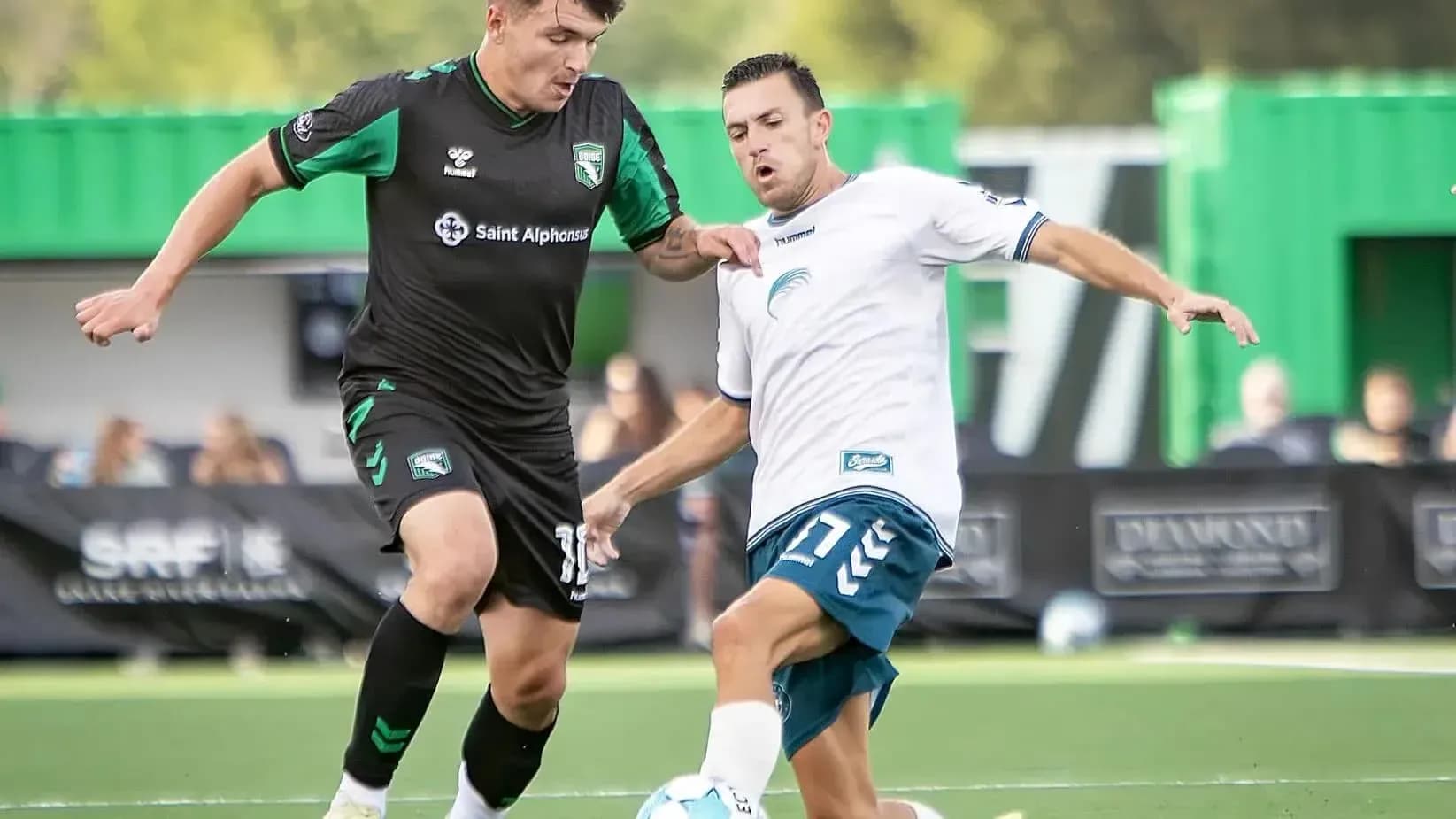 Two players competing for the ball in football match Two players competing for the ball in football match