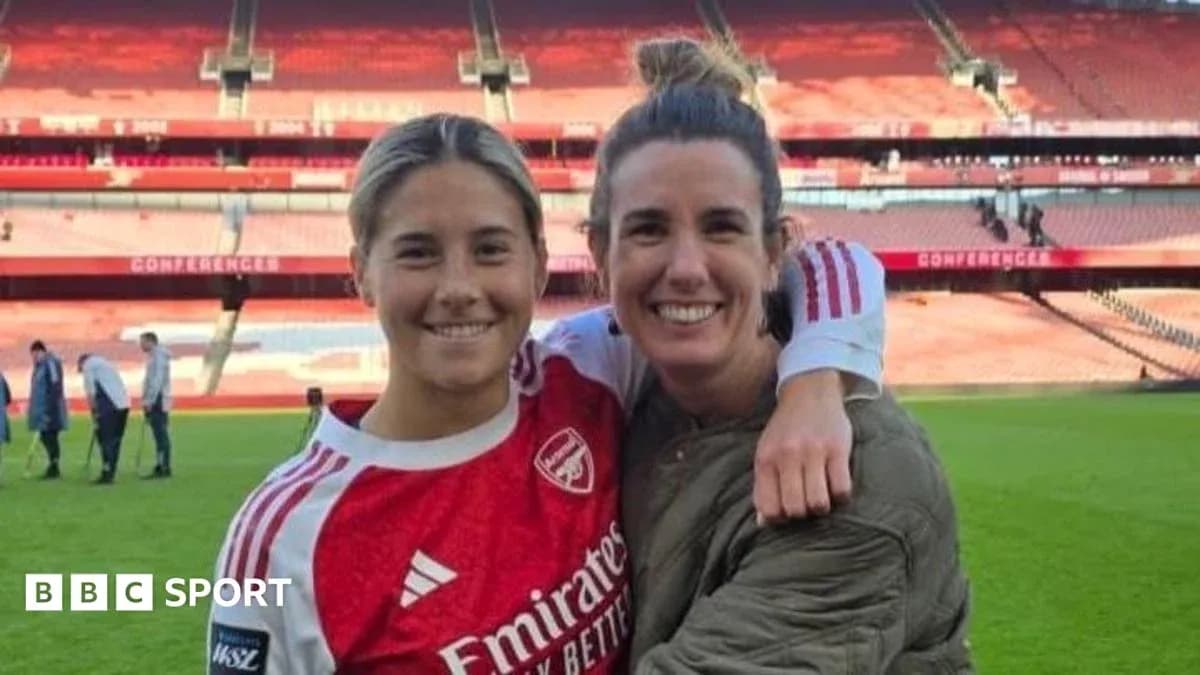 Two women smiling together on football pitch Two women smiling together on football pitch