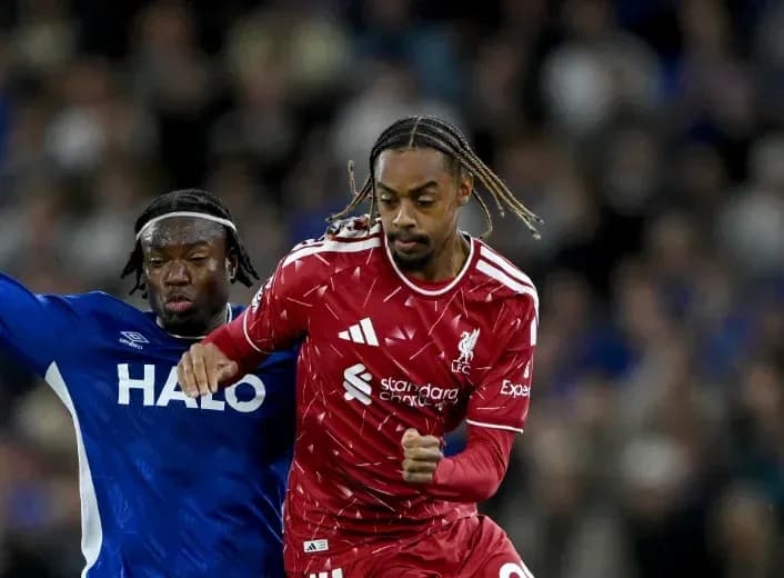Liverpool player evading tackle from opponent during match Liverpool player evading tackle from opponent during match