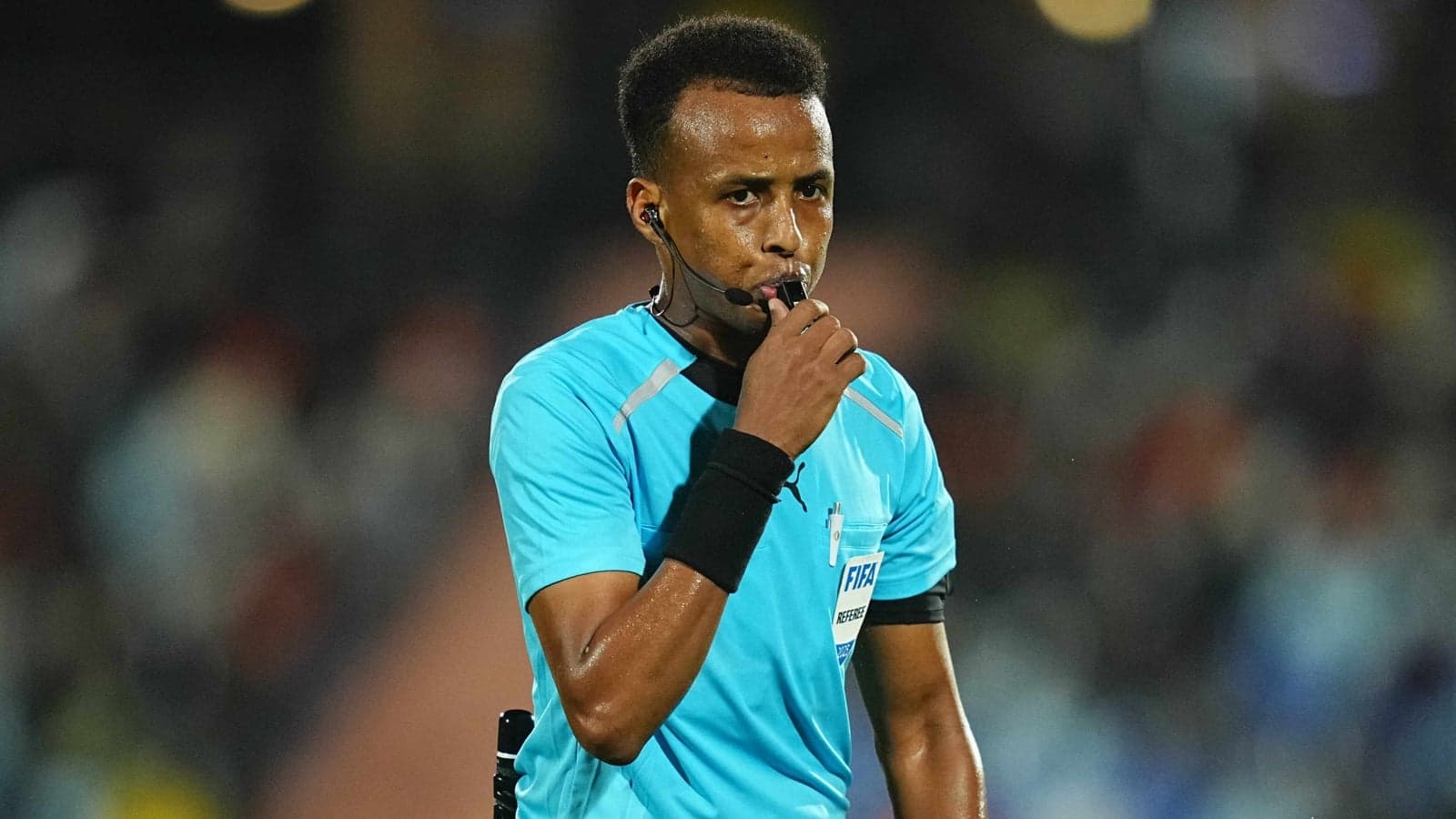 Referee holding whistle during football match Referee holding whistle during football match