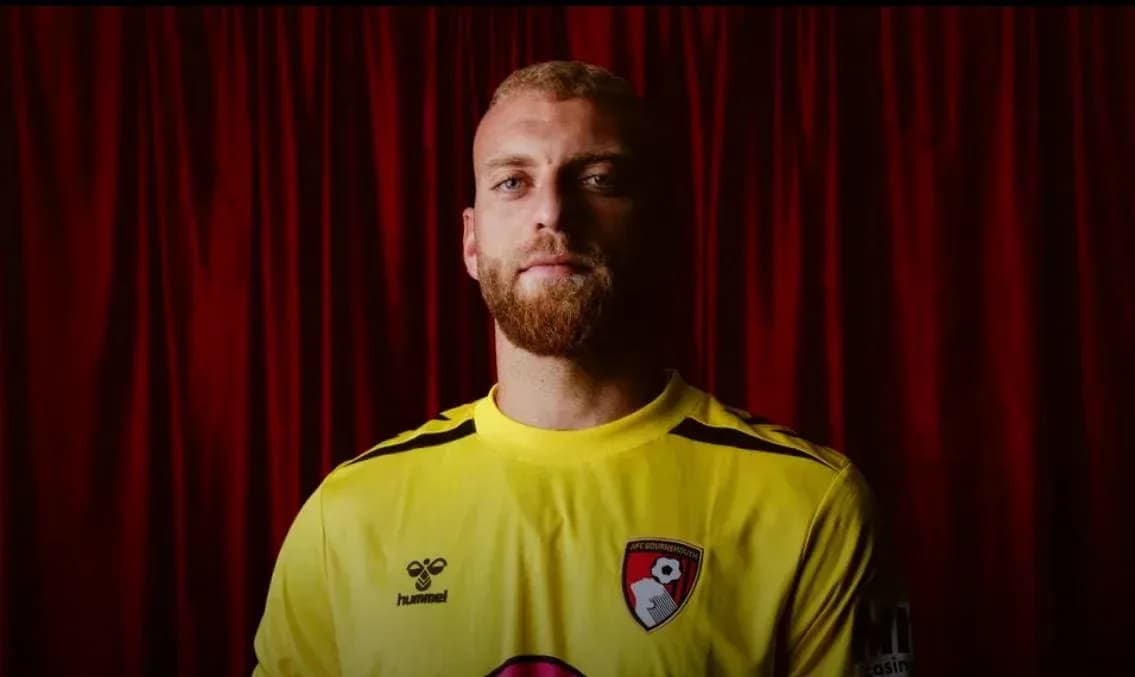 Goalkeeper wearing yellow kit in front of red backdrop Goalkeeper wearing yellow kit in front of red backdrop
