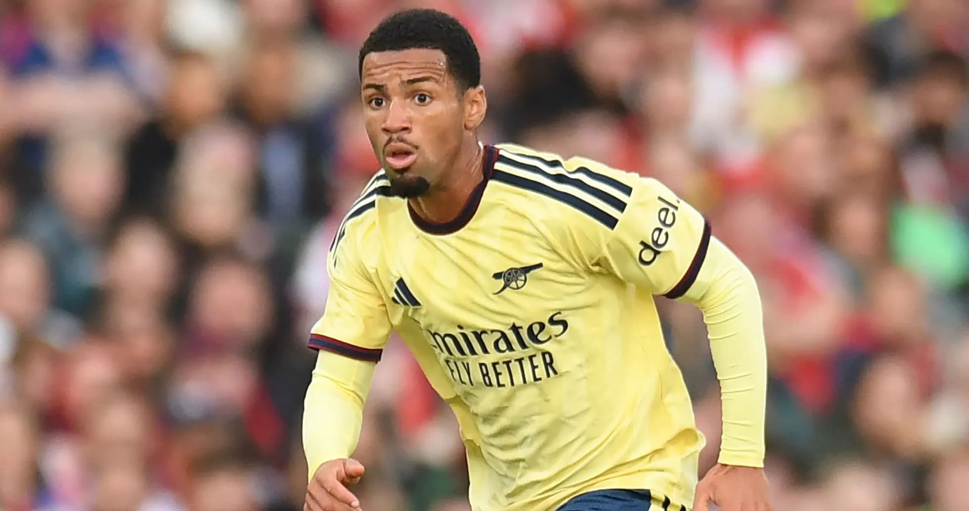 Player in yellow Arsenal kit running during match Player in yellow Arsenal kit running during match