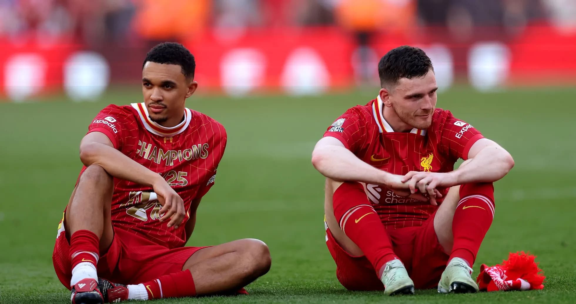 Two Liverpool players sitting on the pitch post-match Two Liverpool players sitting on the pitch post-match