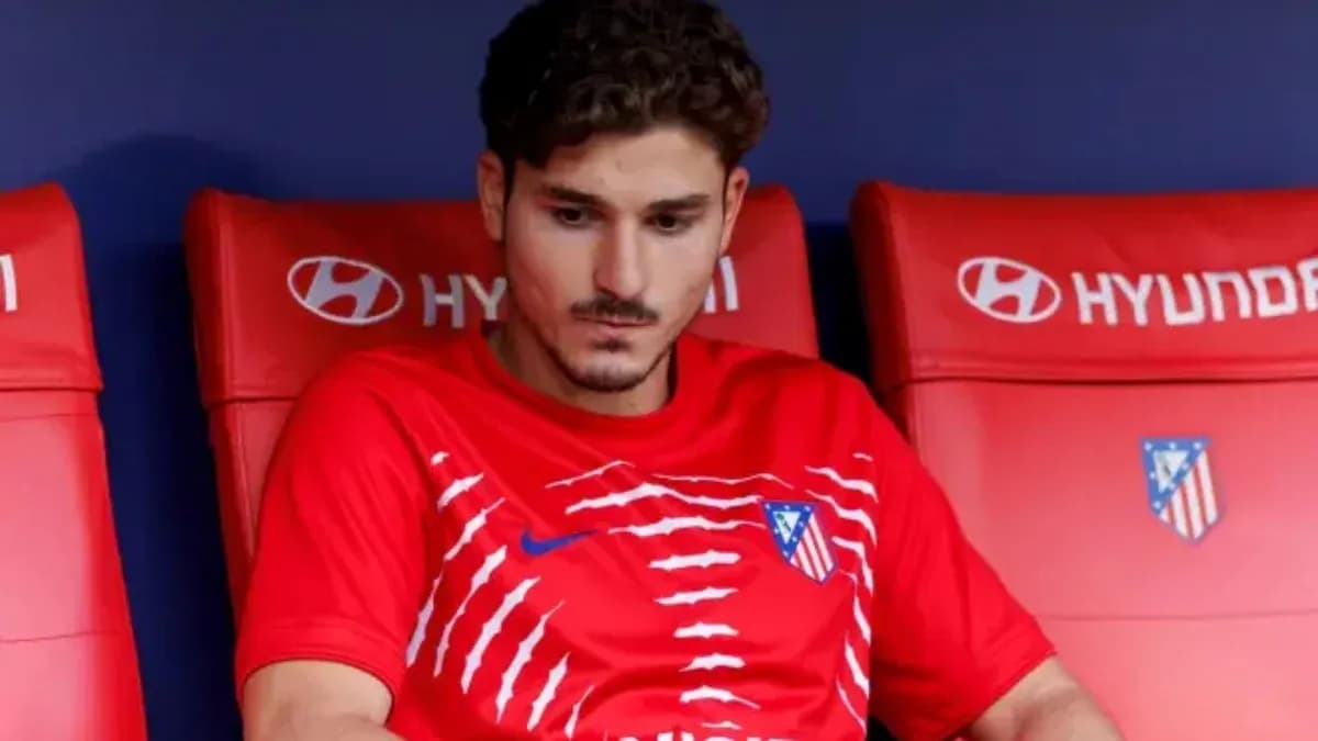 Player sitting on bench wearing Atletico Madrid jersey Player sitting on bench wearing Atletico Madrid jersey