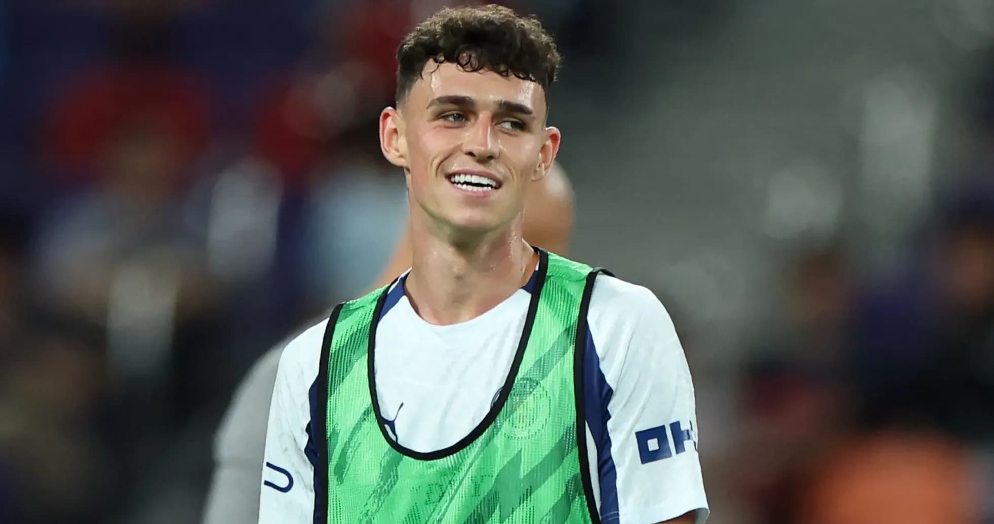 Player smiling while wearing training bib on pitch Player smiling while wearing training bib on pitch