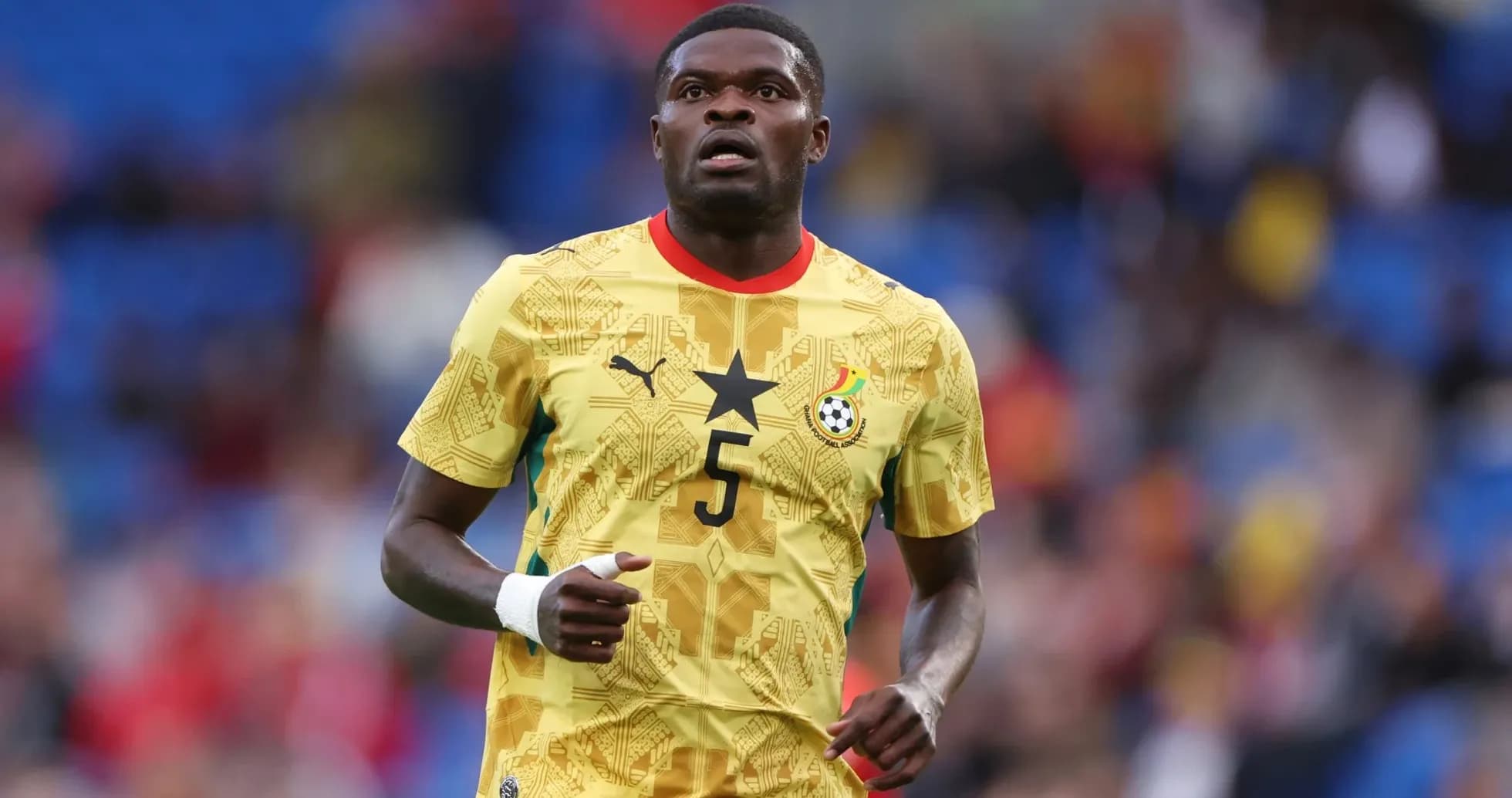Ghanaian player in yellow jersey during match Ghanaian player in yellow jersey during match