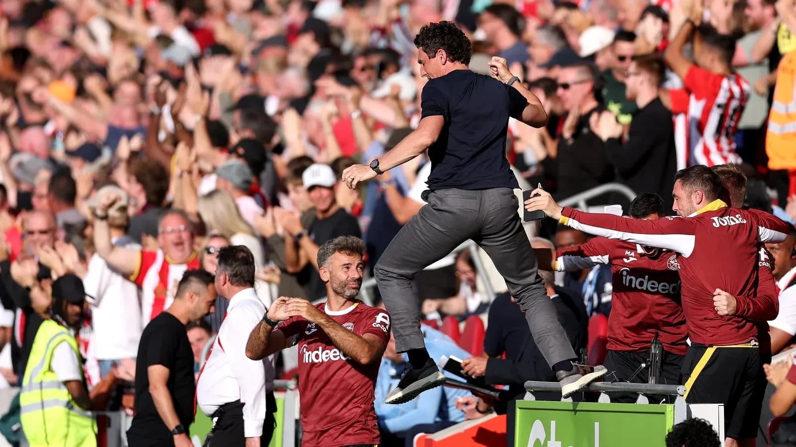 Coach celebrating with fans during match excitement Coach celebrating with fans during match excitement