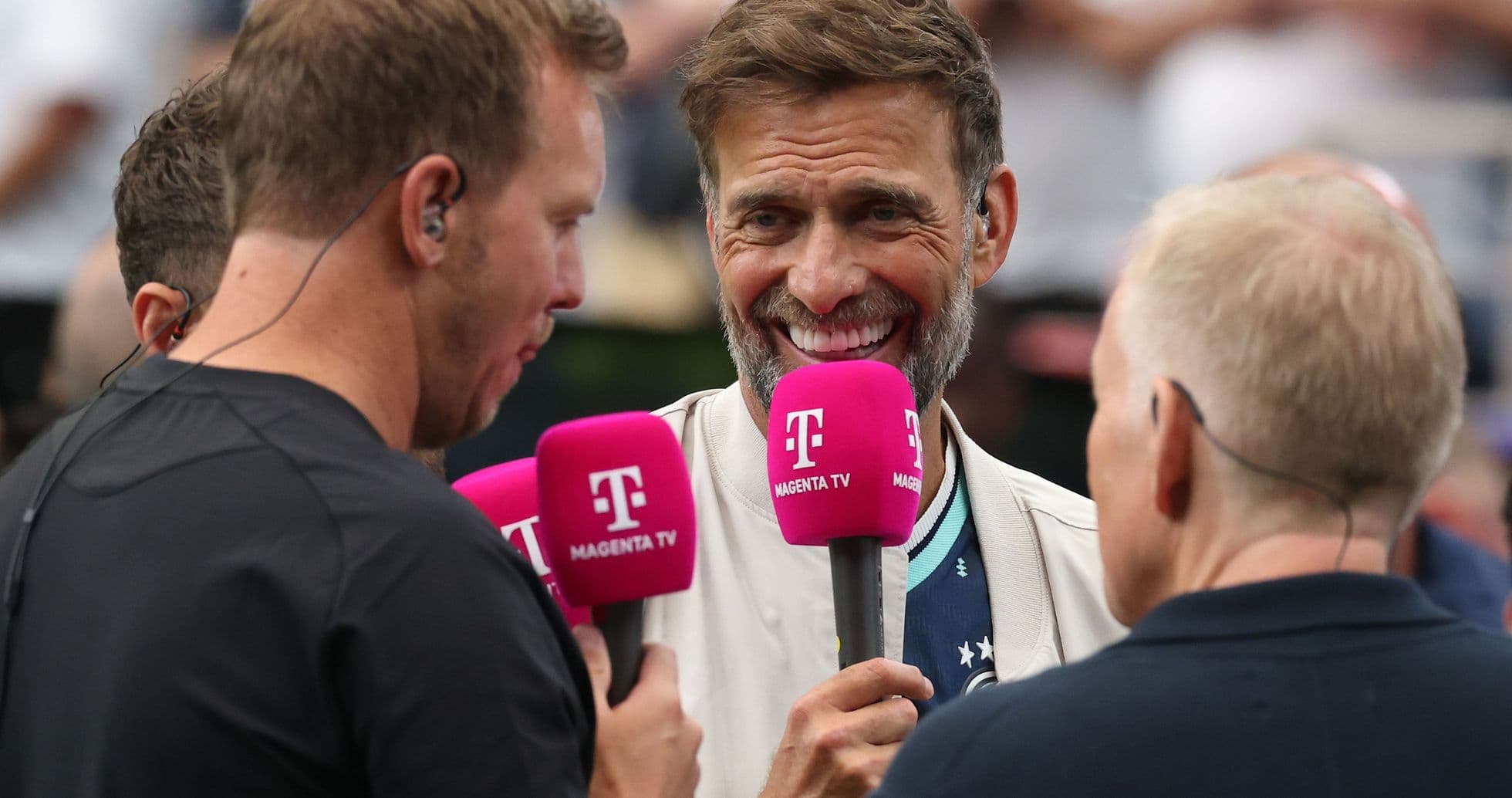 Three commentators holding microphones during interview Three commentators holding microphones during interview