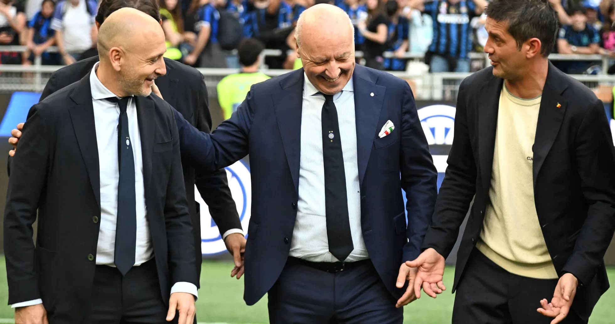 Three men in suits interacting on the field Three men in suits interacting on the field