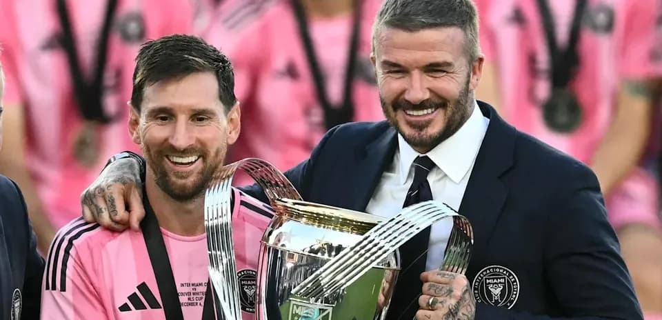 Lionel Messi and David Beckham holding trophy together Lionel Messi and David Beckham holding trophy together